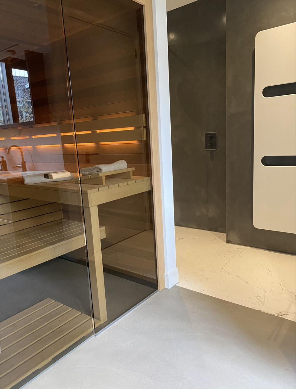 Lavasteen vloer met microcement wand in douche en sauna
