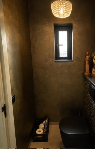 Metallic stuc wand in toilet - goudkleurig effect